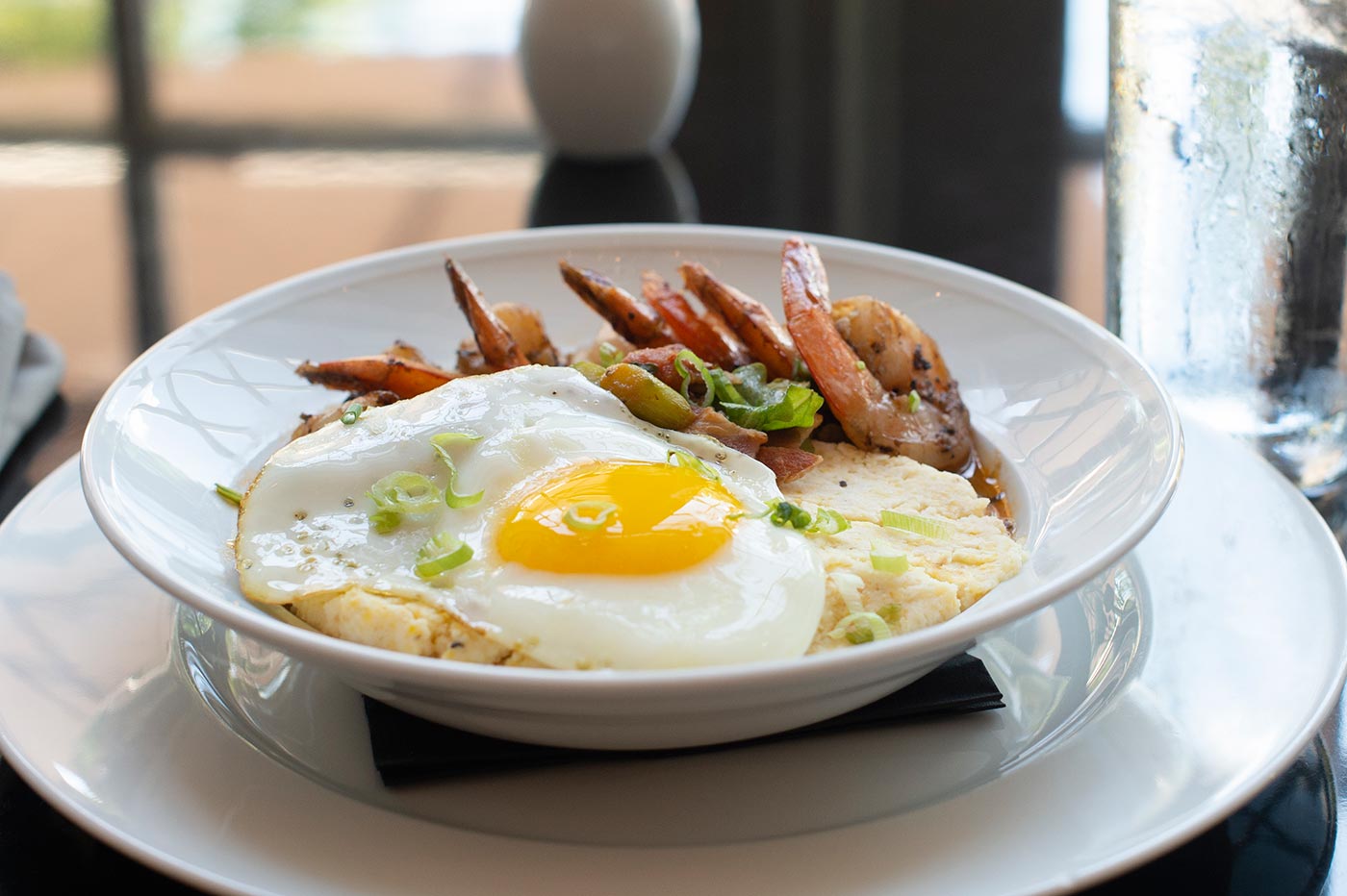 sunnyside up eye on scrambled eggs and side of shrimp