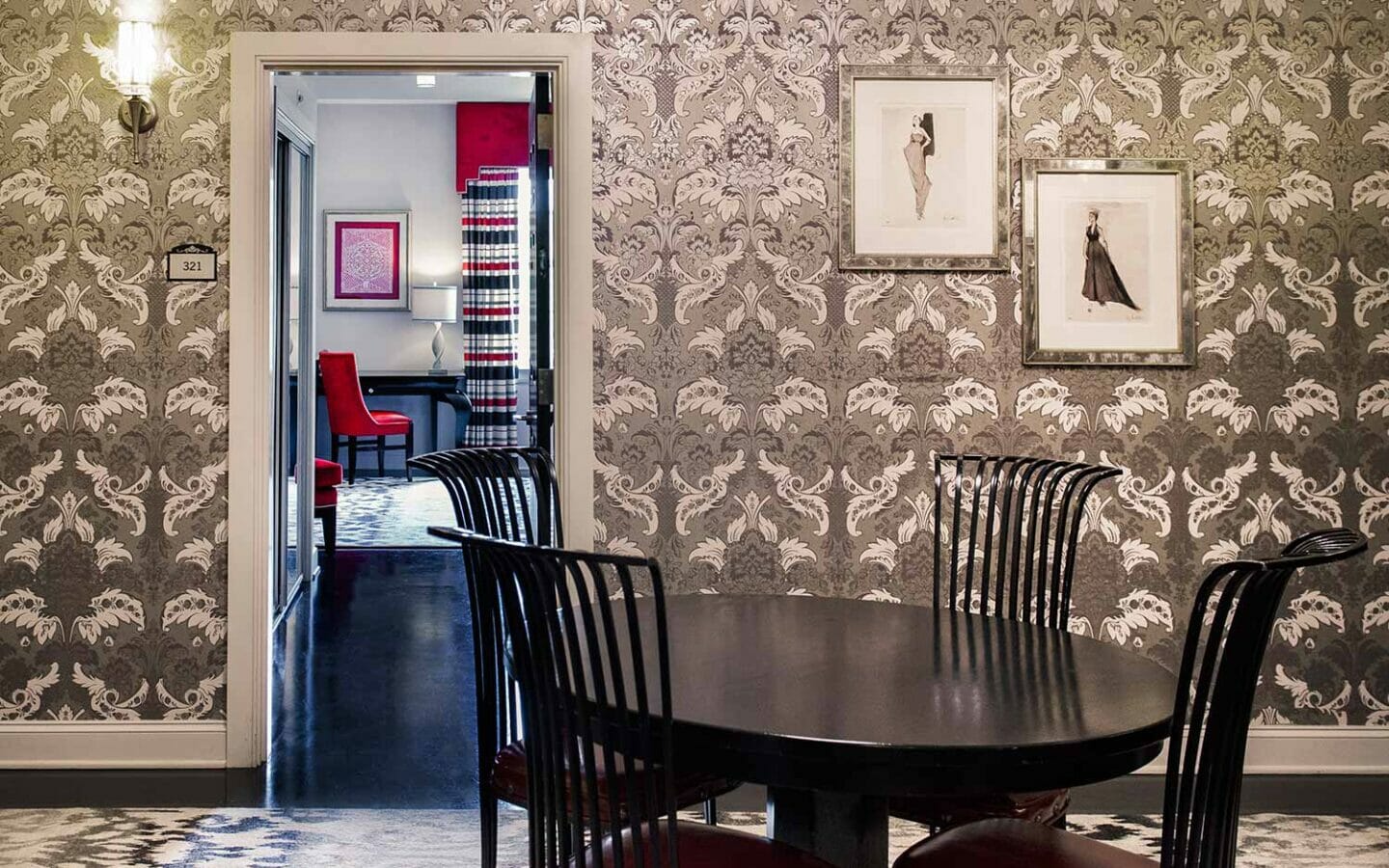 dining table with four chairs in wallpapered room next to bedroom