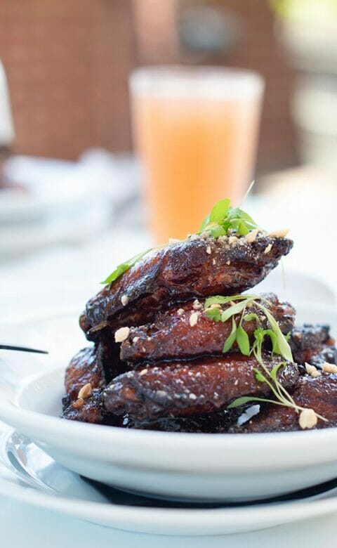 bowl of garnished chicken wings