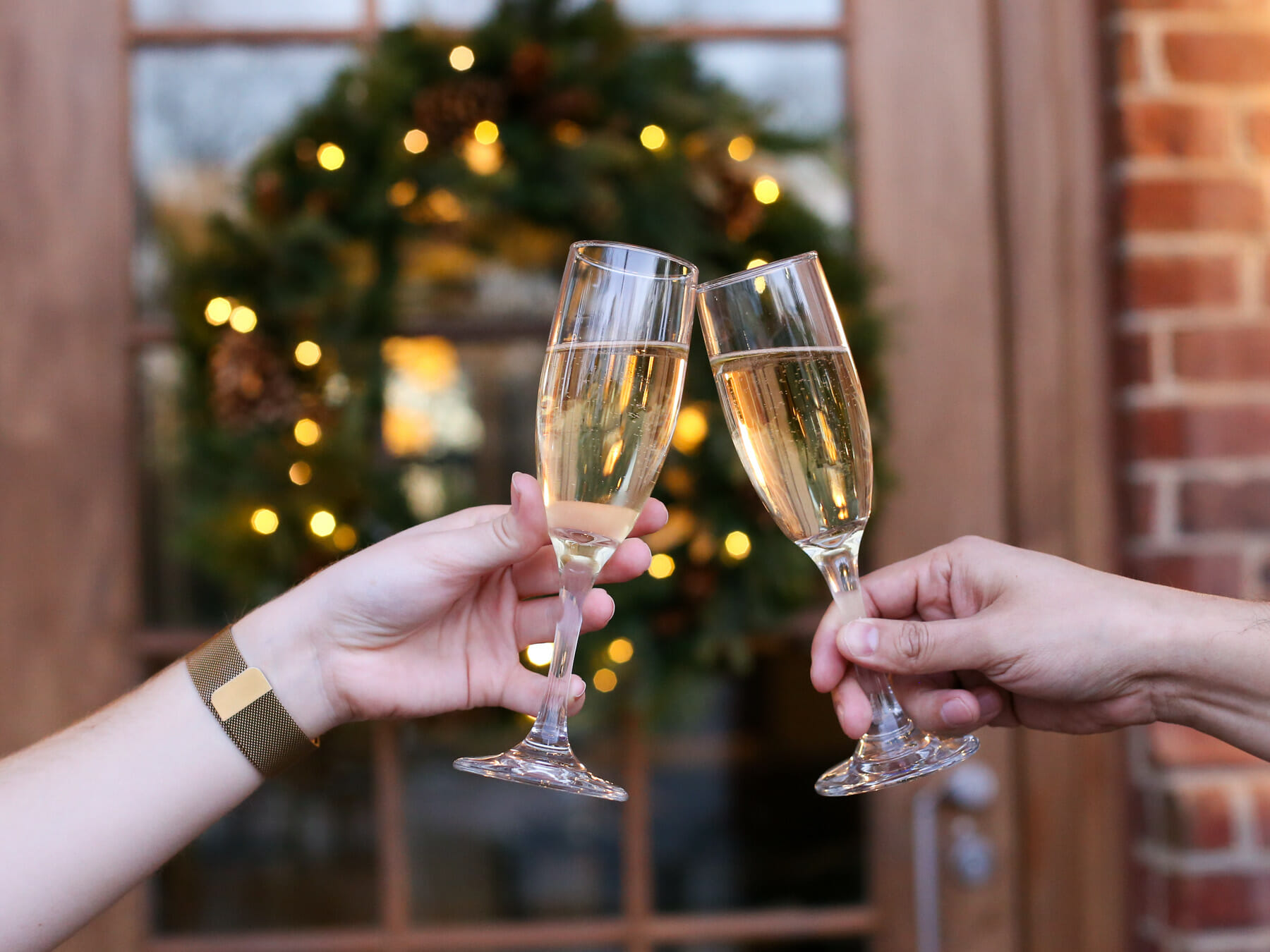 two people clinking champagne glasses