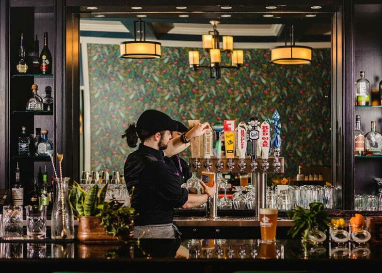 bartender pouring a glass of draught beer