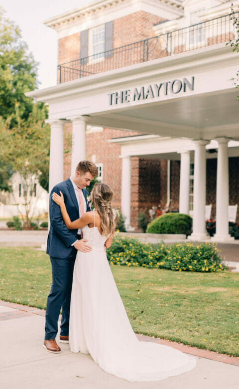 bride and groom standing in front of the mayton